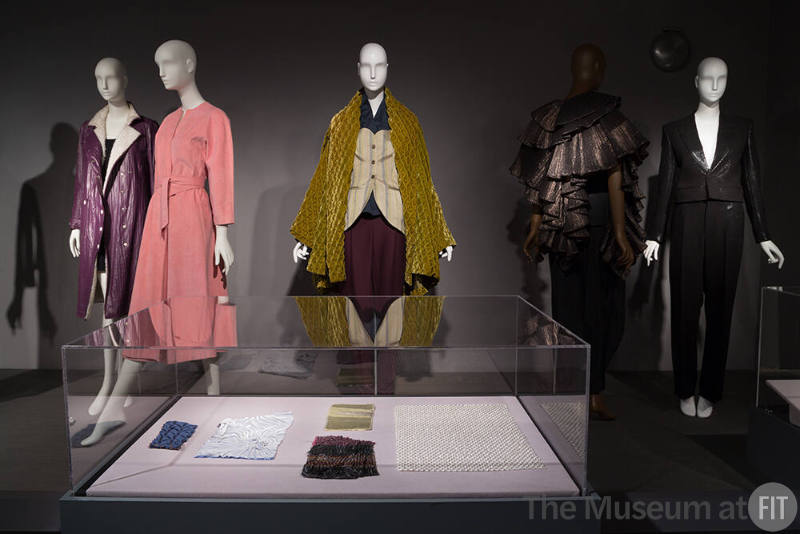 Fabric_33 Left to right 75.94.12 (purple coat), 2017.45.9 (pink dress), P91.53.1 (ensemble), 93.76.82 (cape ensemble), 2018.8.1 (suit), Case Left to right, 91.259.2 (blue), 91.259.3 (velvet), 95.181.3 (gold), 95.181.4 (multicolor), 99.81.6 (white)