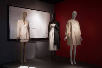 Fashion Unraveled exhibition installation view of dressed mannequins on a platform