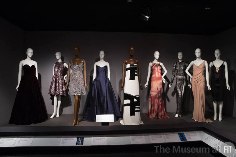 BFD_32  Left to right 77.60.1 (dress), 2016.30.1 (metallic dress), 2016.50.1 (dress), 2016.52.1 (blue gown), 2016.53.1 (dress), 2016.60.1 (gown), 2016.51.1 (cutout dress), 2016.62.2 (dress), 2014.5.1 (black dress)