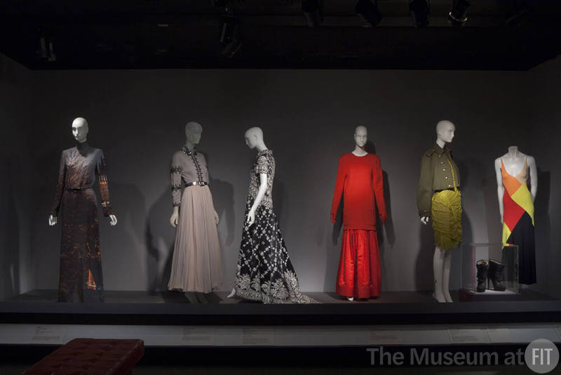 Fashion A-Z (II)_02 Left to right 2011.38.1 (dress), 84.125.7 (ensemble), 2009.16.63 (embroidered dress), 85.91.1 (red ensemble), 2010.62.1 (green ensemble and boots case), 2000.97.1 (dress)