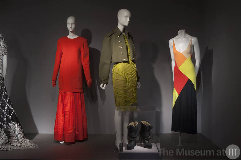 Fashion A-Z (II)_05 Left to right 85.91.1 (red ensemble), 2010.62.1 (green ensemble and boots case), 2000.97.1 (dress)