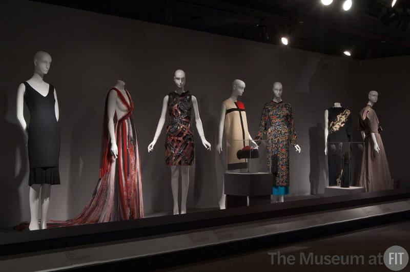 Fashion A-Z (I)_18 Left to right 77.163.7 (dress), 2008.55.1 (dyed gown), 2010.65.2 (dress), 82.52.10 (hat case), 95.180.1 (color block dress), 88.73.1 (printed ensemble), U.2104 (gloves case), 71.263.1 (dress), 2010.1.48 (taupe dress) 