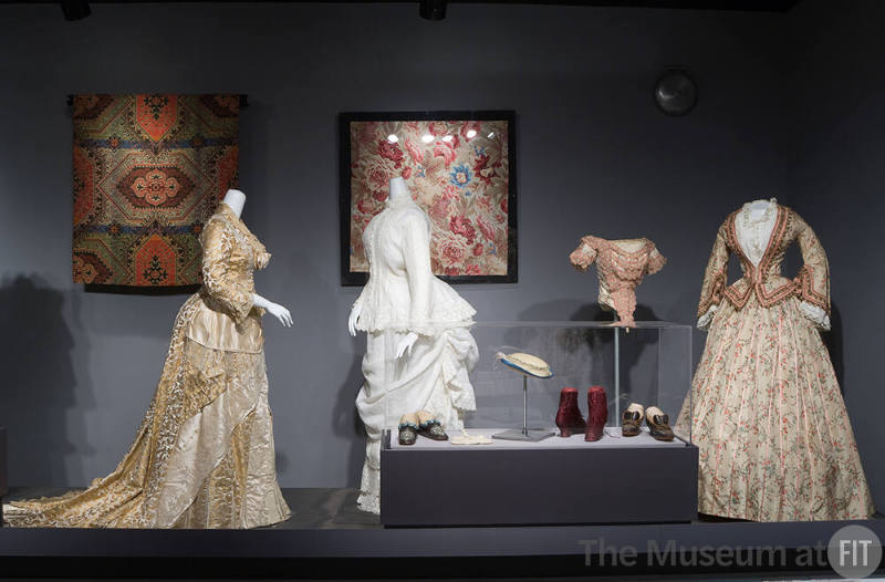 Night and Day_12 Left to right 84.149.1 (textile wall), 72.66.18 (wedding dress), 74.93.19 (ensemble), P80.6.14B (textile wall), P88.14.9, P88.53.15, P88.14.10  (shoes case), P90.26.15 (hat case), 76.208.10 (bodice and bodice and skirt) 
