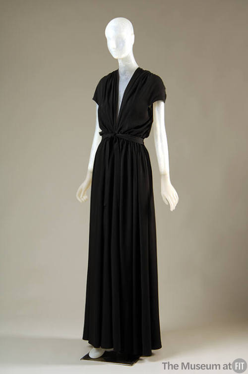 Black short-sleeved, long evening dress with halter styling, draped with tucks across back shou…