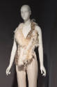 ¾ view of off-white feather and crystal evening set on alternate mannequin in dimly lit gallery