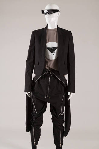 Black cropped blazer; grey t-shirt, black zip front  jumpsuit with large side zippers and front…
