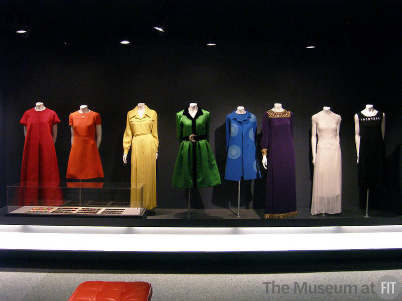 Rainbow_3 Left to right 95.128.1 (red dress), 90.163.3 (orange dress), 90.188.33 (yellow dress), 2005.71.3 (green dress), 78.208.1 (blue coat), 86.7.1 (purple dress), 99.67.1 (white dress), 2003.32.2 (black dress)
