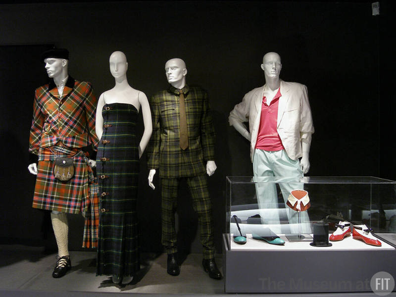 Tailor_15 Left to right  P88.45.2 (tartan ensemble), 89.131.1 (tartan dress), 87.137.1 (tartan ensemble), 89.89.1 (pastel ensemble), 90.59.4 (shoes case), P87.14.2 (hat case), 87.113.1 (bag case), 84.190.1 (shoes case)