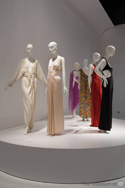 YSL+Halston_16 Left to right  91.104.1 (white dress), 91.235.4 (halter dress), 82.3.5 (purple dress), 87.146.27 (floral dress), 88.1.69 (orange dress), 79.66.40 (black jumpsuit)