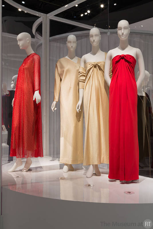 YSL+Halston_35 Left to right 82.3.1 (orange caftan), 92.109.4 (satin dress), 82.3.9 (dress and stole), 80.128.4 (red dress)