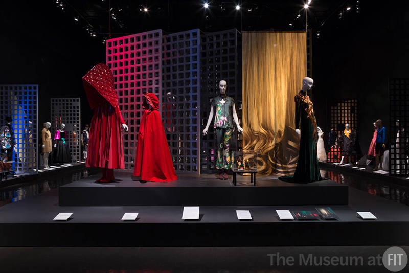 Exhibitionism_24 Left to right 2015.8.1 (red ensemble), 2002.36.1 (red cape), 2008.45.1 (pants ensemble and shoes case), 2005.24.1A  (textile hanging), 2013.2.1 (gold and velvet gown) 