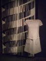 Light grey A-line mini dress, cap sleeves, belted drop waist, and round patch pockets
