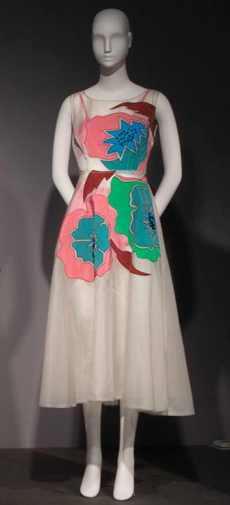 White sheer sleeveless dress with pink, blue, green and red floral appliques on bodice and top …