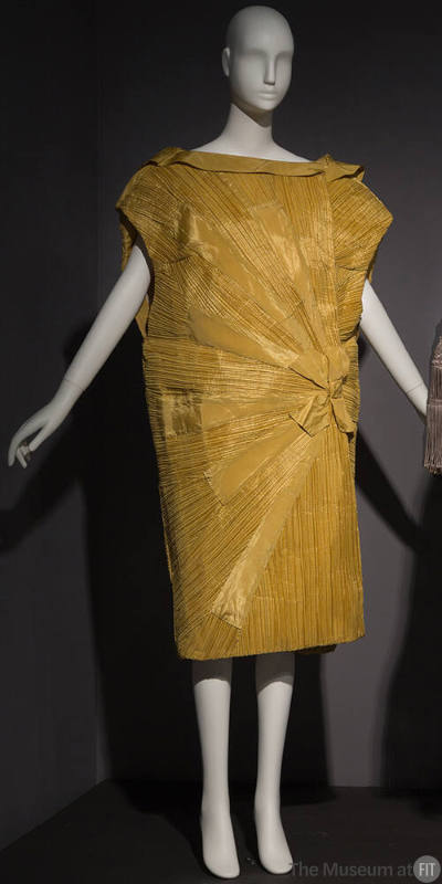 Yellow pleated sleeveless cocoon style evening coat with fold over collar and bow and sunburst …