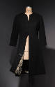 Black collarless coat with front hook and eye closures and bottom hem open to reveal black and …
