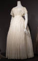 Sheer white short sleeve floor length dress shirred overall with fitted empire waist and flared…