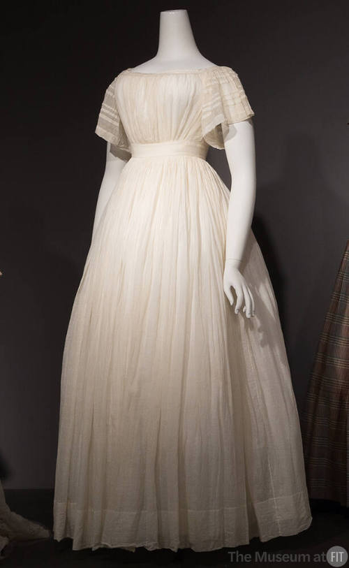 Sheer white short sleeve floor length dress shirred overall with fitted empire waist and flared…