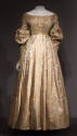 Gold and white silk floral dress with smocked bodice, wide neck, long puffed sleeves, floor-len…