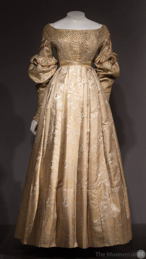 Gold and white silk floral dress with smocked bodice, wide neck, long puffed sleeves, floor-len…