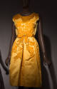 Yellow gold silk satin sleeveless knee length dress with velvet floral design across center, ma…