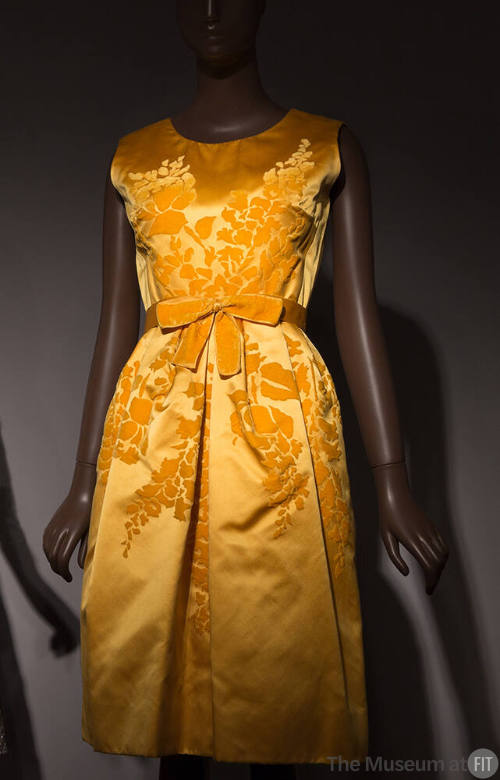 Yellow gold silk satin sleeveless knee length dress with velvet floral design across center, ma…