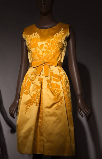 Yellow gold silk satin sleeveless knee length dress with velvet floral design across center, ma…
